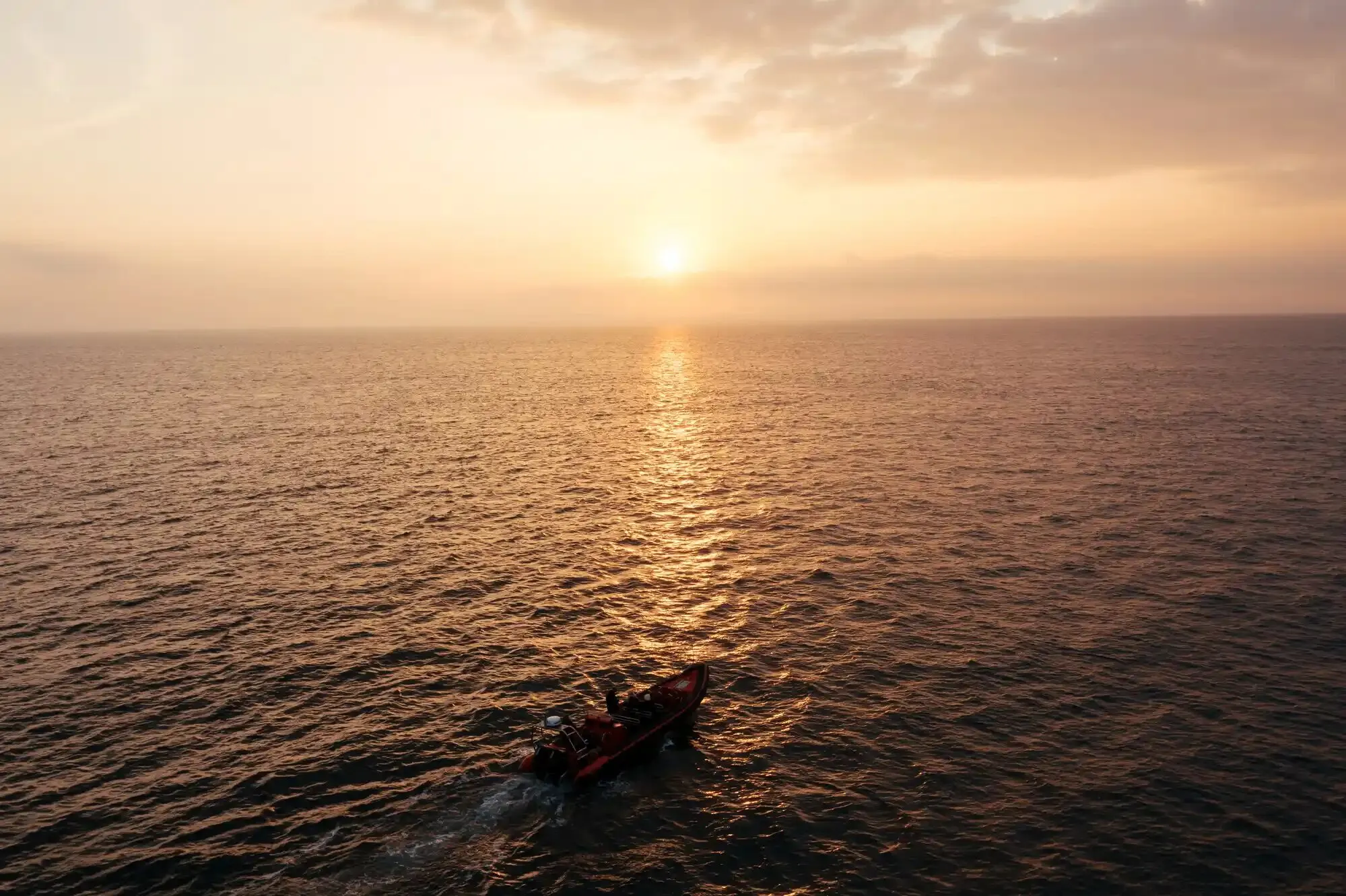 A boat at sea at sunset